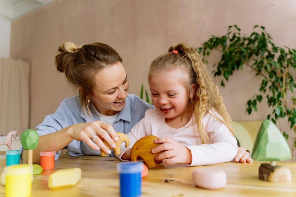 Mom and daughter playing with wooden toys. 